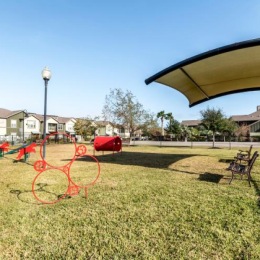 fenced in dog park with an awning