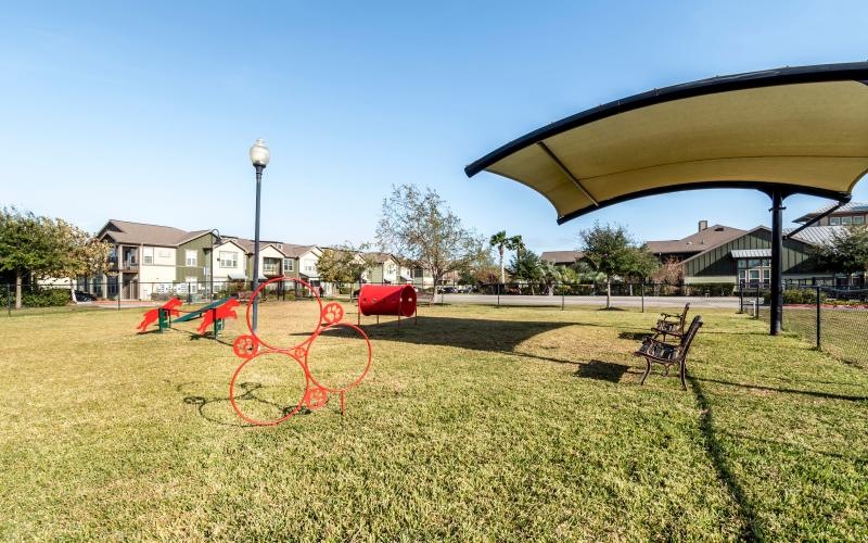 fenced in dog park with an awning