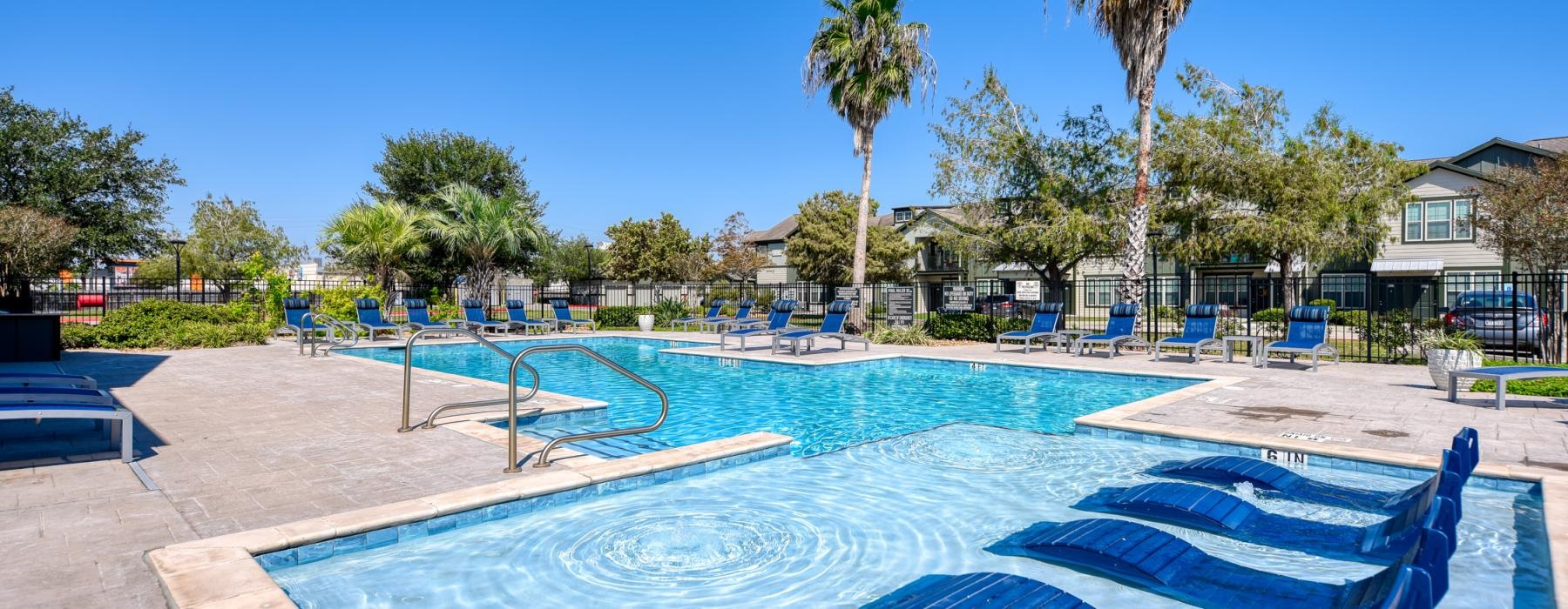 a swimming pool with trees and houses in the background